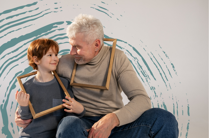 Older man and young child wearing picture frames like necklaces