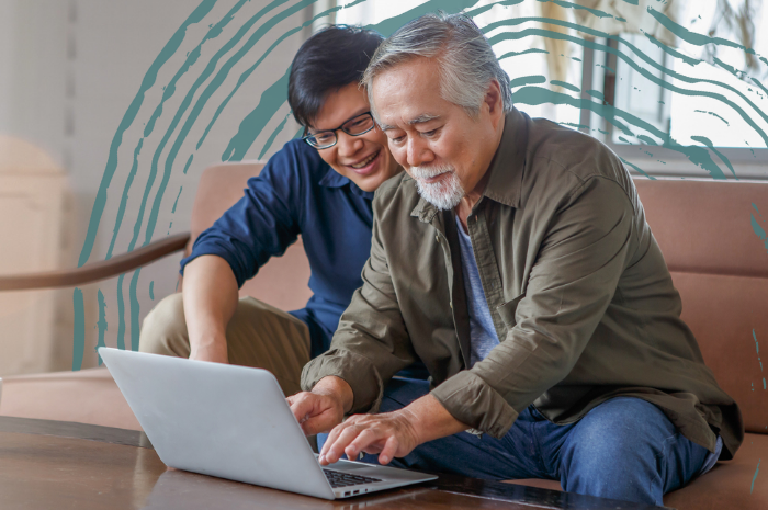 An older man and a younger man looking at a laptop computer