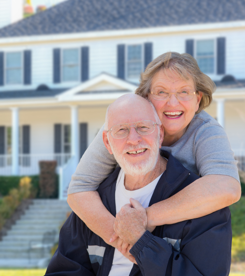 Older couple in front of their home